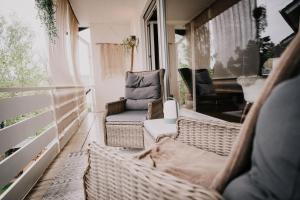 a balcony with chairs and a couch and a piano at SOONWALD Apartment mit Garten & Hot Tube in Stromberg