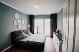 1 dormitorio con 1 cama en una habitación con ventana en SOONWALD Apartment mit Garten & Hot Tube, en Stromberg