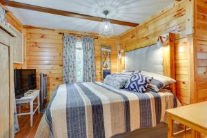 - une chambre avec un lit et une télévision dans l'établissement Pet-Friendly Haleyville Cabin Rental with Kayaks!, à Haleyville