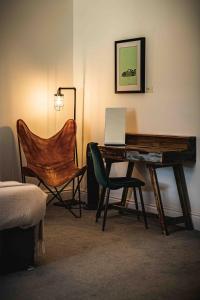 a desk with a laptop and a chair in a room at Caffeine&Machine in Stratford-upon-Avon