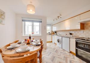 a kitchen with a wooden table and a dining room at Dune View Instow in Instow