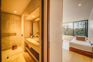 un bagno con un lavandino e un letto in una stanza di Panoramic 3BR PH with Private Pool a Tulum Altre 37 foto