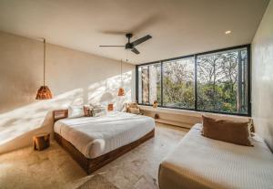 una camera da letto con due letti e una grande finestra di Panoramic 3BR PH with Private Pool a Tulum