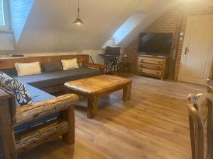 a living room with a couch and a tv at Apartmany pod schodami in Banská Štiavnica