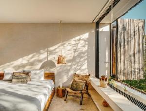 una camera da letto con un letto e una grande finestra di Panoramic 3BR PH with Private Pool a Tulum
