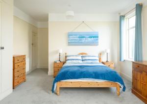 a bedroom with a bed with a blue comforter at Francis Cottage in Woolacombe