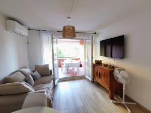 een woonkamer met een bank en een televisie bij Superbe appartement Cap d'Agde in Cap d'Agde