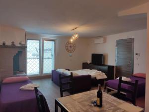 a room with two beds and a living room with a table at Villa Vita - Monolocale con giardino in Acilia