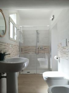 a bathroom with a sink and a toilet and a shower at Villa Vita - Monolocale con giardino in Acilia