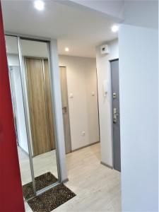 a hallway with a mirror and some doors at Apartament KOPERNIK X in Biała Podlaska