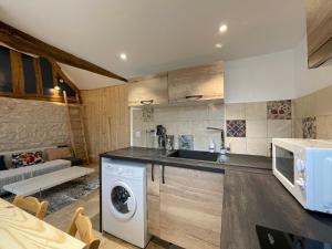 a kitchen with a washer and dryer in a room at La chapelle de Monet - logis Eglantine in Bois-Jérôme-Saint-Ouen