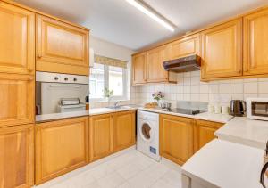 cocina con armarios de madera y lavavajillas en Spindrift Cottage Berrynarbor en Berrynarbor