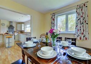 a dining room with a table with plates and wine glasses at Cleeve in Barnstaple