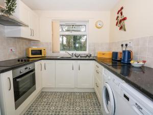 a kitchen with white cabinets and a sink at 8 Royal Chalet Park in Norwich