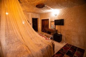 a bedroom with a bed with a curtain on it at Katapa Special Cave in Çavuşin