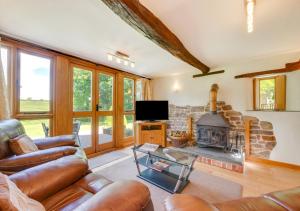 a living room with a couch and a fireplace at Meadowside Barn in Meshaw