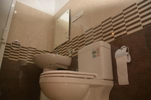 y baño con aseo y espejo. en Leon Hilltop Resort, en Kitulgala