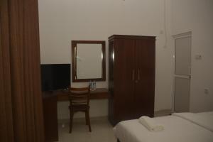 a bedroom with a desk and a chair and a mirror at Leon Hilltop Resort in Kitulgala