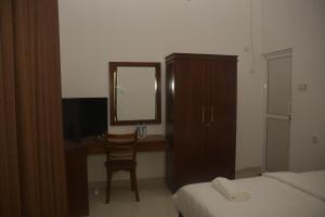 um quarto com uma secretária, uma cadeira e um espelho em Leon Hilltop Resort em Kitulgala
