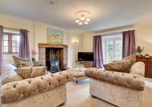 a living room with two couches and a fireplace at Nethercott Manor in Rose Ash