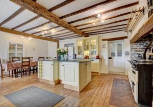 Nethercott Manor في Rose Ash: مطبخ مع دواليب بيضاء وغرفة طعام