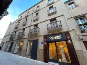 a store in front of a building with a window at Olivae Hostal Boutique in Cáceres