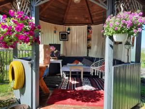 a gazebo with a table and flowers in it at Vintage and cozy room, free parking, shared house in the small quiet village in Alba Iulia