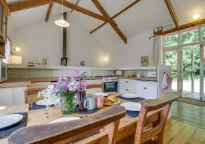 a kitchen with a wooden table with flowers on it at Mole Cottage in Parracombe
