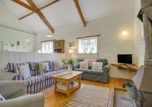 uma sala de estar com sofás e uma televisão em Mole Cottage em Parracombe