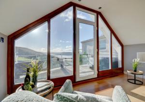 a living room with large windows and a table and chairs at Ocean Villa in Woolacombe