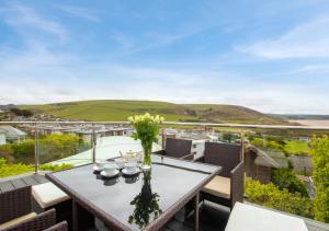 a table on a balcony with a view of the ocean at Ocean Villa in Woolacombe