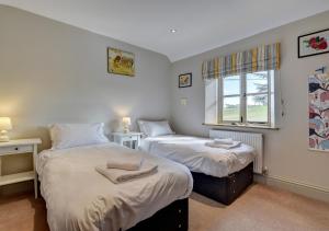 2 Einzelbetten in einem Zimmer mit Fenster in der Unterkunft Northcote Lodge in Burrington