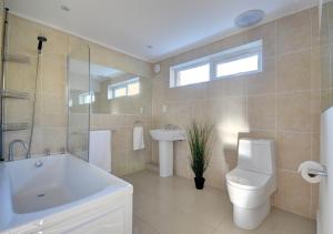 a bathroom with a tub and a toilet and a sink at Ocean Villa in Woolacombe