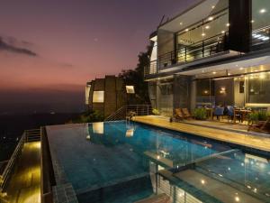 a house with a swimming pool at night at GreenAcres Leisure Resort in Kandy