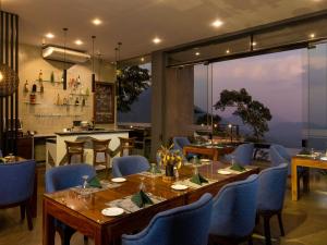 a dining room with a table and blue chairs at GreenAcres Leisure Resort in Kandy