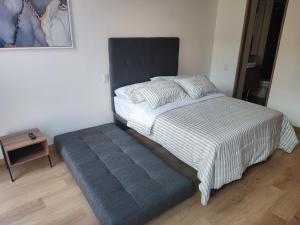 uma cama com um grande repousa-pés azul num quarto em Aparta Suite - Centro Internacional - Mitika em Bogotá