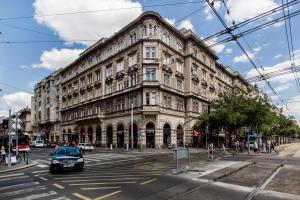 een groot gebouw aan een stadsstraat met een auto bij Home in the living Budapest in Boedapest
