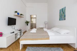 ブダペストにあるHome in the living Budapestの白いベッドルーム(ベッド1台、薄型テレビ付)