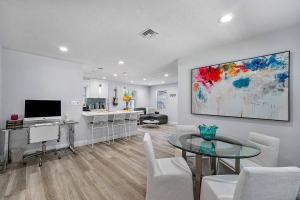 a living room with a glass table and a kitchen at Casita Delray in Delray Beach