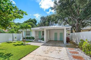 a home with a white fence and a yard at Casita Delray in Delray Beach