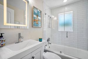 a bathroom with a sink and a tub and a toilet at Casita Delray in Delray Beach +24 photos
