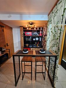 uma cozinha com uma mesa e duas cadeiras num quarto em Studio Aisiki - Apartamento em Brasília em Brasília