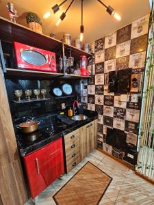 a kitchen with a sink and a red microwave at Studio Aisiki - Apartamento em Brasília in Brasília