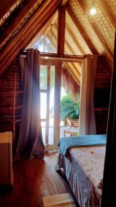 ein Schlafzimmer mit einem Bett in einem Zimmer mit einem Fenster in der Unterkunft Chalés do Pedro Hospedagem e Restaurante in Praia de Araçatiba