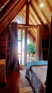 a bedroom with a bed in a room with a window at Chalés do Pedro Hospedagem e Restaurante in Praia de Araçatiba