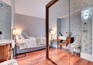 a mirror in a bedroom with a bed and a desk at The Oriel in Lynmouth