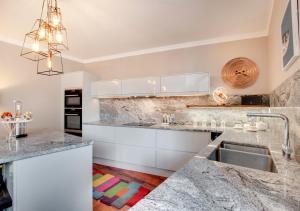 a kitchen with white cabinets and marble counter tops at The Oriel in Lynmouth