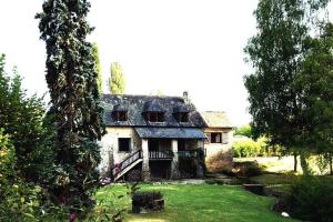 ein altes Haus mitten im Garten in der Unterkunft Le Moulin de la Rode in Coly