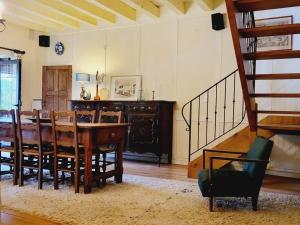 ein Esszimmer mit einem Tisch, Stühlen und einer Treppe in der Unterkunft Le Moulin de la Rode in Coly