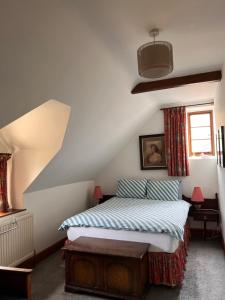 a bedroom with a bed and a window and a staircase at Converted Coach House Holt, Wiltshire in Holt